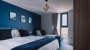 Una habitación de hotel con dos camas, un ventanal con cortinas y una obra de arte en la pared.