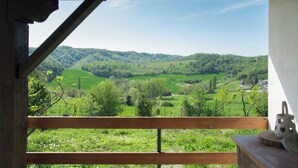 A wooden bench overlooking a lush green valley with a clear sky. - MONFERRATO VACATIONS VACATION HOME (Ottiglio)
