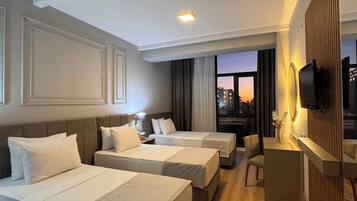 Deluxe trippelrum - 3 enkelsängar - viss havsutsikt | Värdeförvaringsskåp på rummet, skrivbord och arbetsyta för laptop