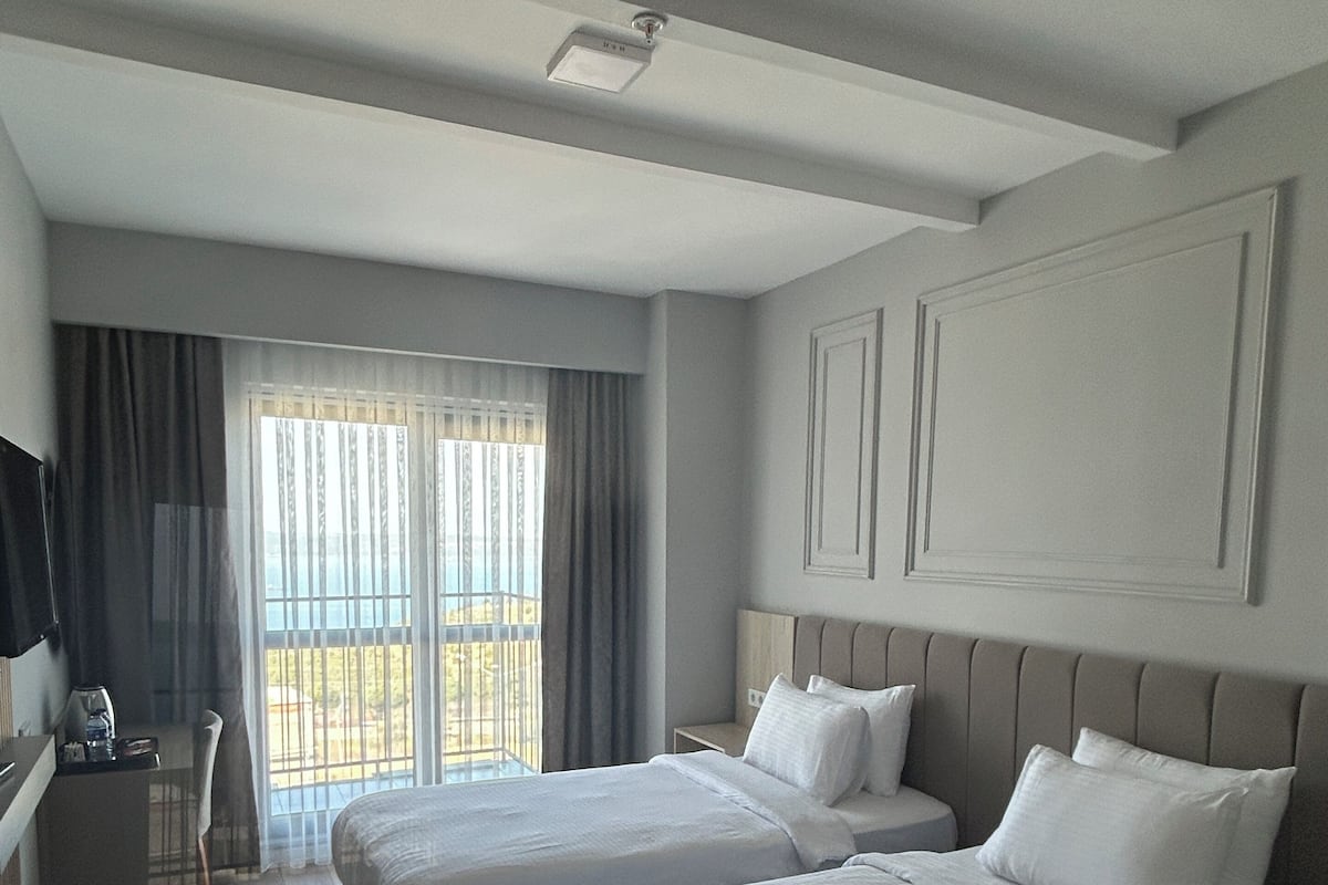 Habitación superior con 2 camas individuales, balcón, vista al mar | Caja de seguridad en la habitación y escritorio