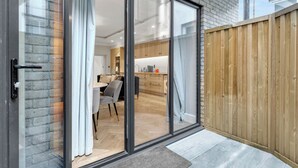A modern kitchen with wooden cabinets and a dining area with a table and chairs.