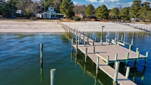 A wooden pier extending into calm water, with a house and trees in the background. - All Year Retreat - Indoor Heated Pool, Beach, Game & Movie Cottage, Sleeps 21 (Hague)