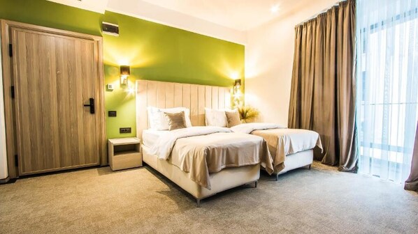 Une chambre d’hôtel avec un grand lit, une table de chevet, une armoire et une vue sur l’extérieur par la fenêtre.
