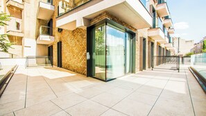 Un bâtiment moderne doté d’une entrée en verre, d’une façade en briques et d’un sol carrelé.