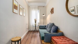 Ein gemütliches Wohnzimmer mit einer Couch, einem kleinen Tisch und einem Hocker.