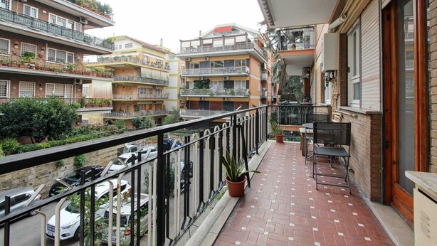 A balcony with a tiled floor, potted plants, and a chair. - Quiet and charming house near Trastevere (Roma)