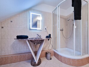 Een douche, een haardroger, handdoeken, toiletpapier
