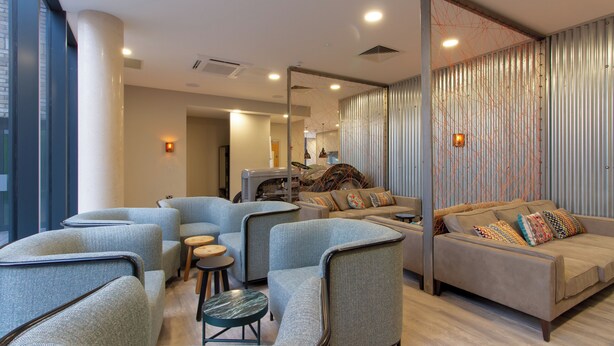 A modern lounge area with curved seating, a sofa, and a coffee table.