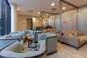 Un'area lounge moderna con sedute curve, un divano e un tavolino.