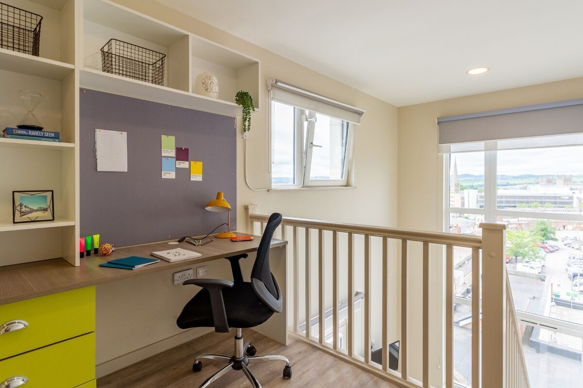 A modern office space with a desk, chair, and shelves.