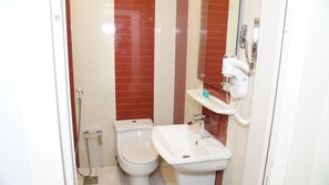Et badeværelse med toilet, bidet og vask.