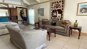 A living room with a sofa, a coffee table, and a painting on the wall. - Big Vacation Plex (Freeport)