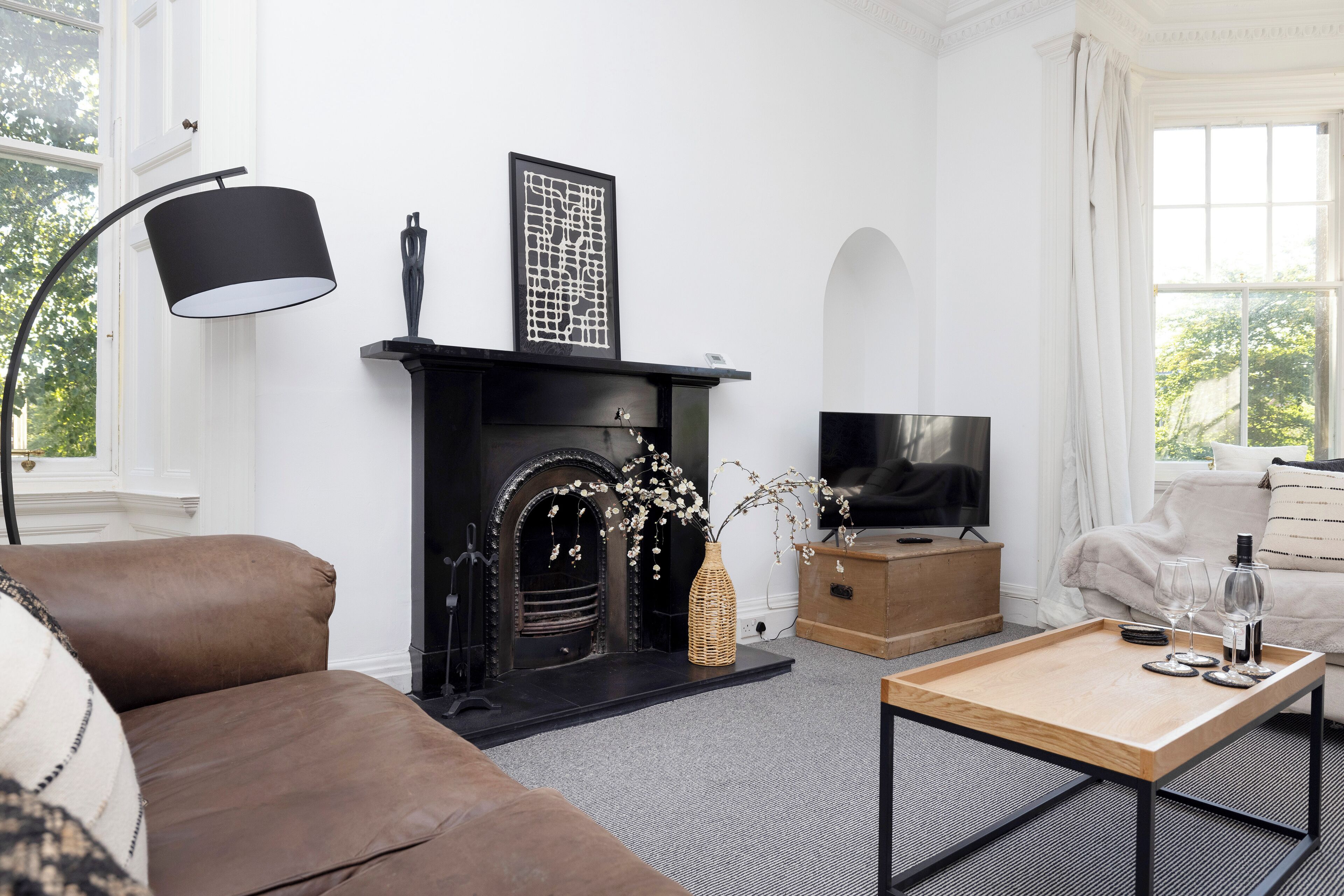 A living room with a fireplace, sofa, coffee table, and television.