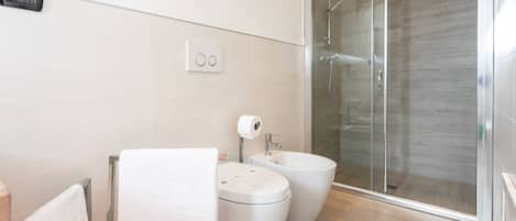 Een douche, een haardroger, een bidet, handdoeken