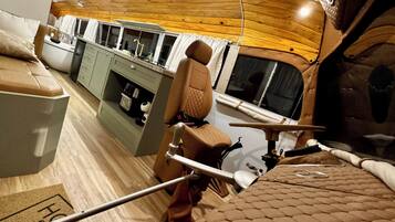 Cozy interior space with a kitchenette and dining area featuring a cushioned bench.