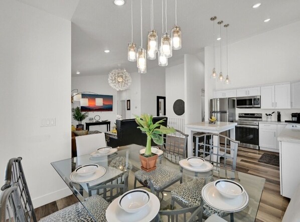 Una cocina moderna con armarios blancos, electrodomésticos de acero inoxidable y una isla central.