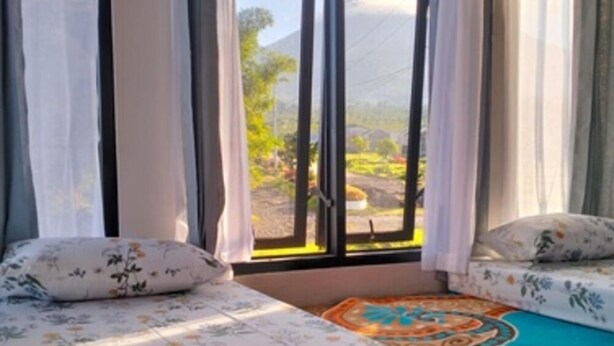Una camera da letto con un letto, una finestra con tende e vista sul paesaggio.