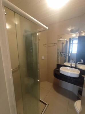 A bathroom with a glass shower enclosure, a white sink, and a mirror above the sink. - Conforto a Beira Mar no Golden Fortaleza (Fortaleza)