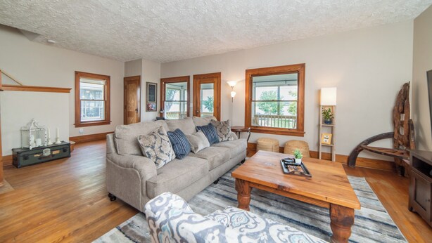 A spacious living room with a large sofa, a wooden coffee table, and a fireplace.