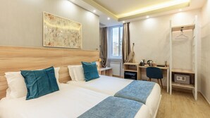 A hotel room with two beds, a desk, a chair, and a wardrobe. - Leone d'Oro Guesthouse (Rome)