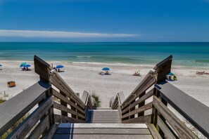 A wooden staircase leading to a beach with umbrellas and beach chairs. - Hidden Beach Villas 122 - A Sunset Paradise (Santa Rosa Beach)