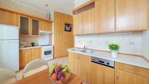 A kitchen with wooden cabinets, a white refrigerator, a stove, a sink, and a dishwasher.
