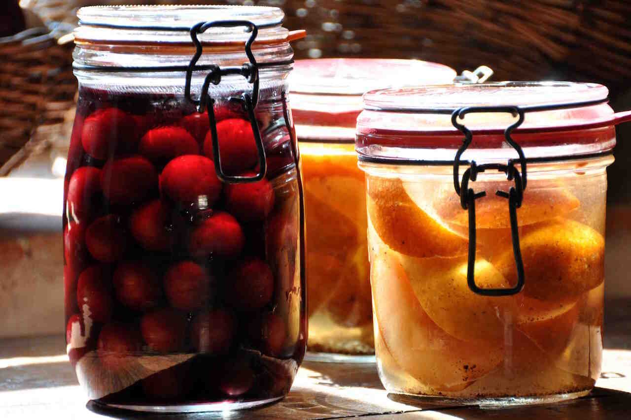 Trois bocaux en verre munis de fermetures métalliques, contenant des fruits confits.