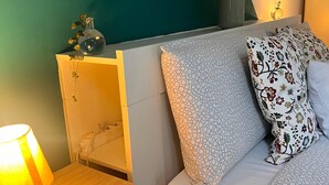 A neatly arranged bedroom with a bed, a bedside table with a lamp, and a wall-mounted shelf with decorative items. - 10 minutes from the Duomo LA TERRAZZA SU MILANO offers a moment of tranquility (Milano)