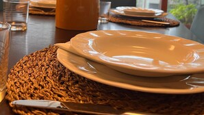 A dining table set with plates, cutlery, and a vase with flowers. - 10 minutes from the Duomo LA TERRAZZA SU MILANO offers a moment of tranquility (Milano)