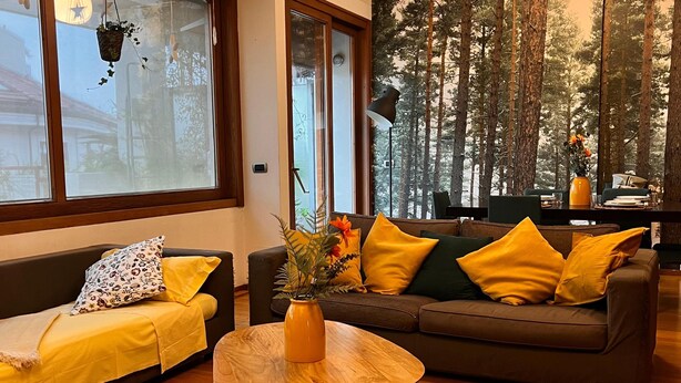 A modern living room with a sofa set, a coffee table, and a large window with a forest view. - 10 minutes from the Duomo LA TERRAZZA SU MILANO offers a moment of tranquility (Milano)