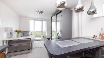 A modern kitchen with a central island, pendant lights, and a view to the outside.
