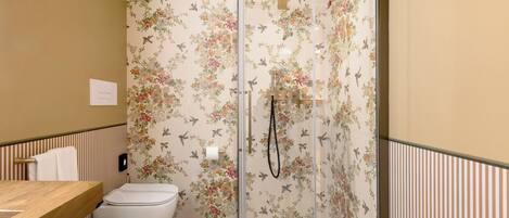 A bathroom with a shower, toilet, and bidet.