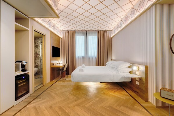 A hotel room with a bed, a desk, a TV, and a bathroom visible through an open door. - QC room Milano Porta Romana (Milan)