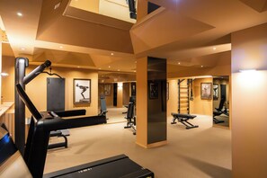 A gym with exercise equipment, a treadmill, and a mirrored wall. - QC room Milano Porta Romana (Milan)