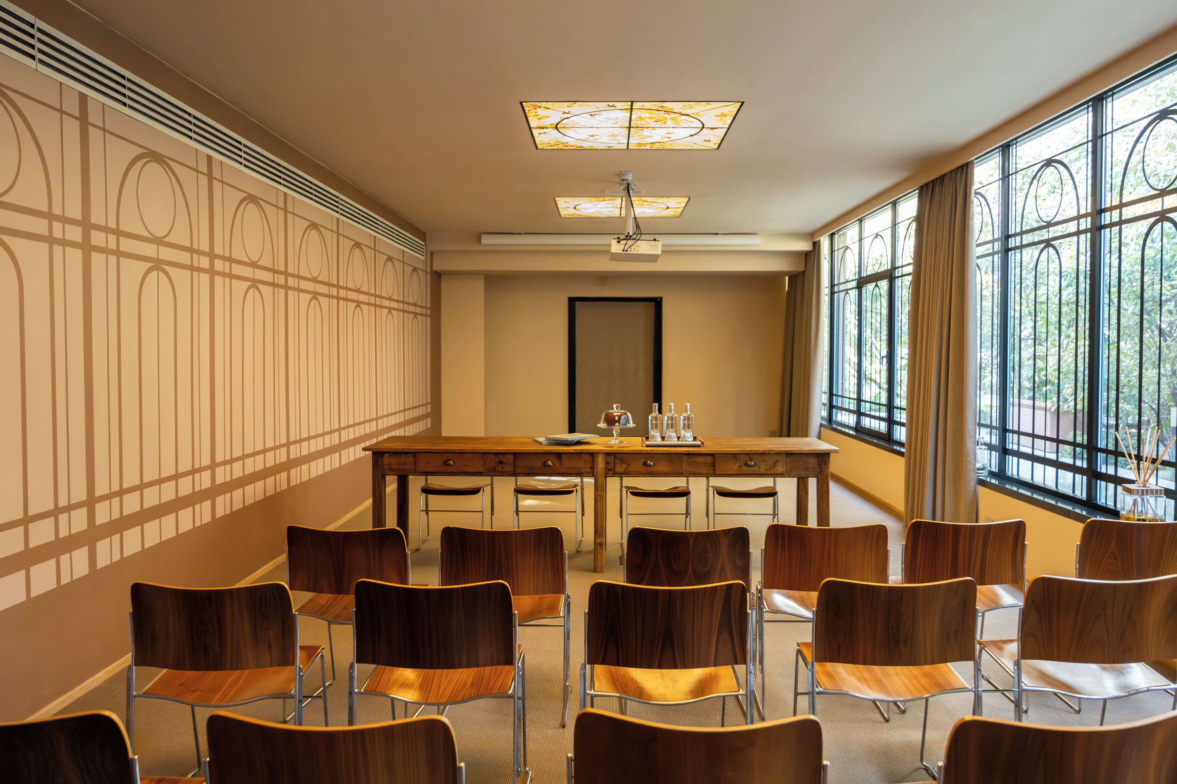 A conference room with a long table, chairs, a projector, and a large window with a view.