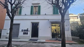 A building with a white facade, green shutters, and a visible storefront with a sign reading "PARRUGCHIERI Gialle".