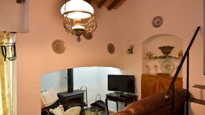 A cozy living room with a fireplace, a television, and a brown leather sofa. - Casa dos Avós - Two Bedroom House, Sleeps 4 (Évora Monte)