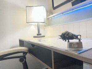 Un escritorio con una lámpara, un reloj y una figurita de toro.