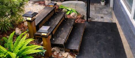 A wooden deck with benches, a wooden fence, and potted plants.