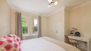 Un dormitorio con cama, escritorio y silla.