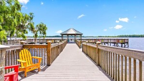 A wooden pier leading to a gazebo with a view of the water. - Living the Disney Dream! | Lake View Luxury Condo (Orlando)