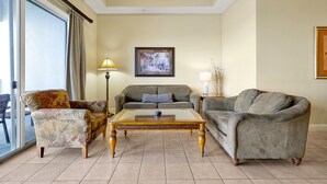 A living room with a sofa, armchair, and coffee table. - Living the Disney Dream! | Lake View Luxury Condo (Orlando)