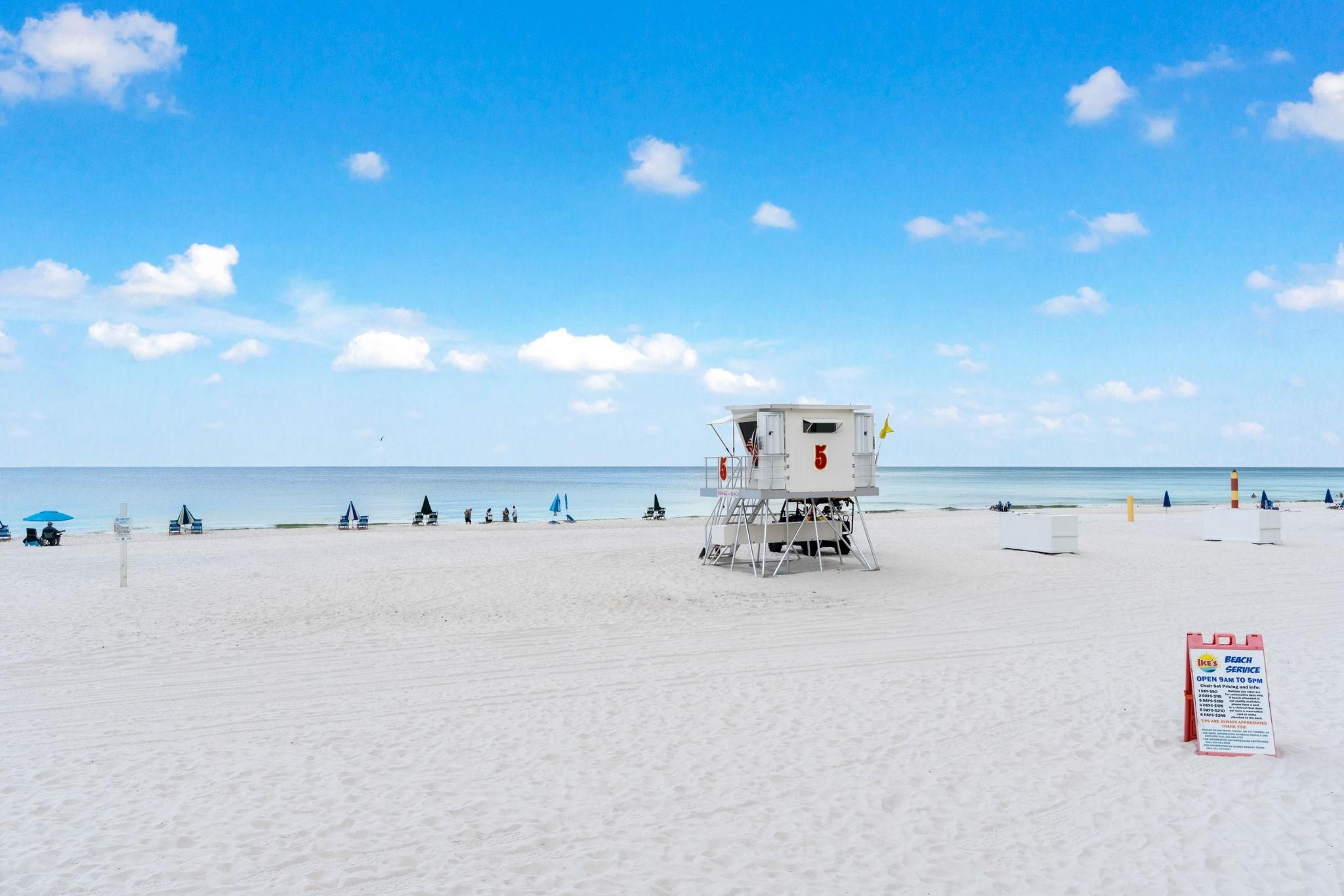Ein Rettungsschwimmturm am Strand bei strahlendem Himmel.