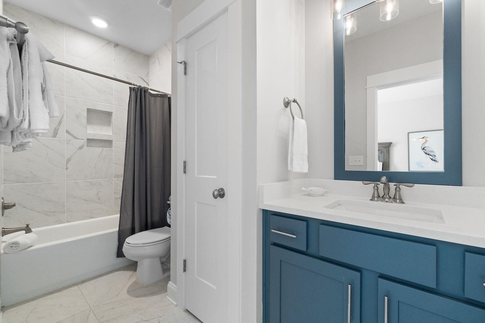 Bagno con vasca, servizi igienici e mobile lavabo con specchio.