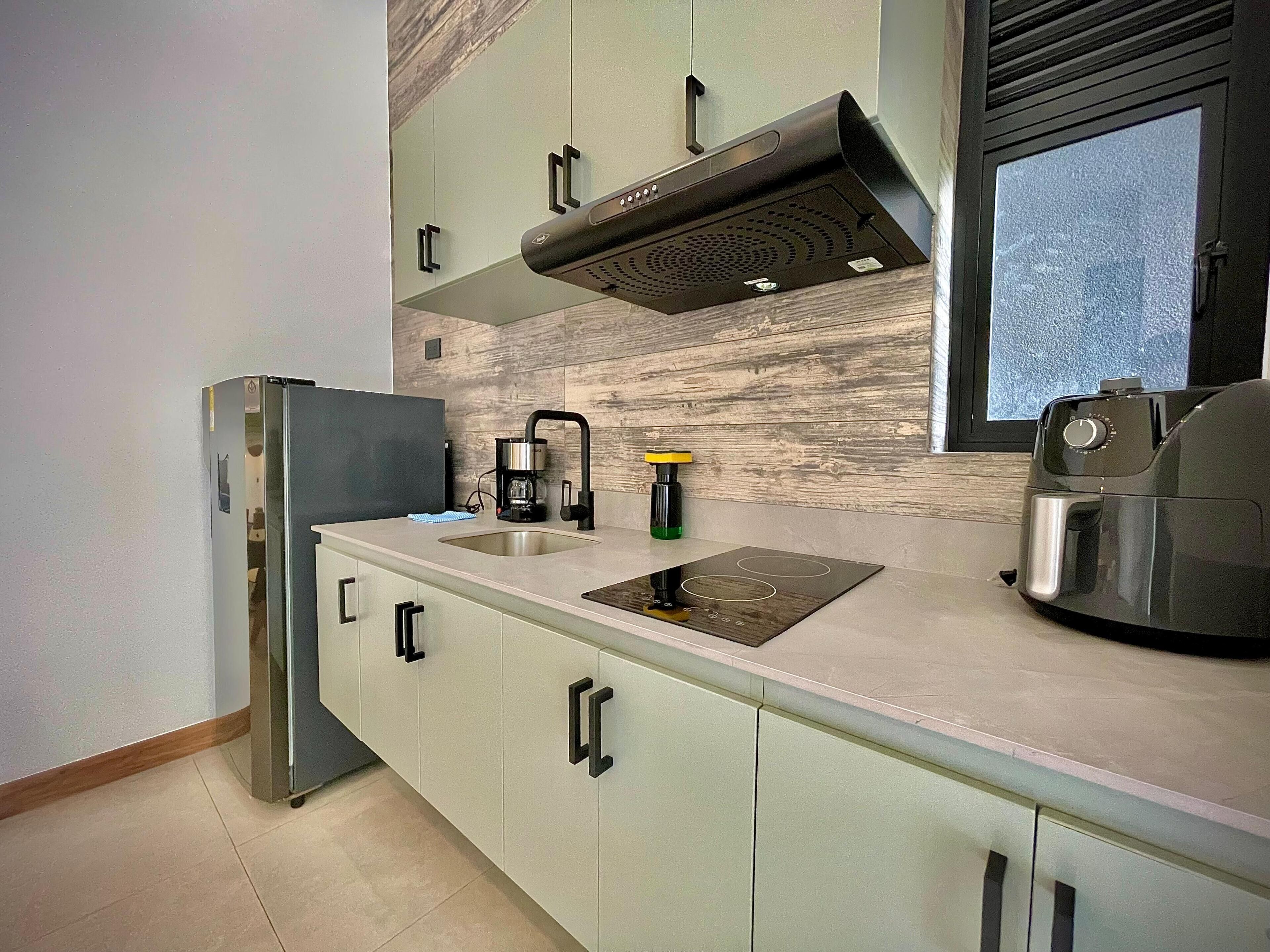 A modern kitchen with a built-in stove, a coffee maker, and a sink.