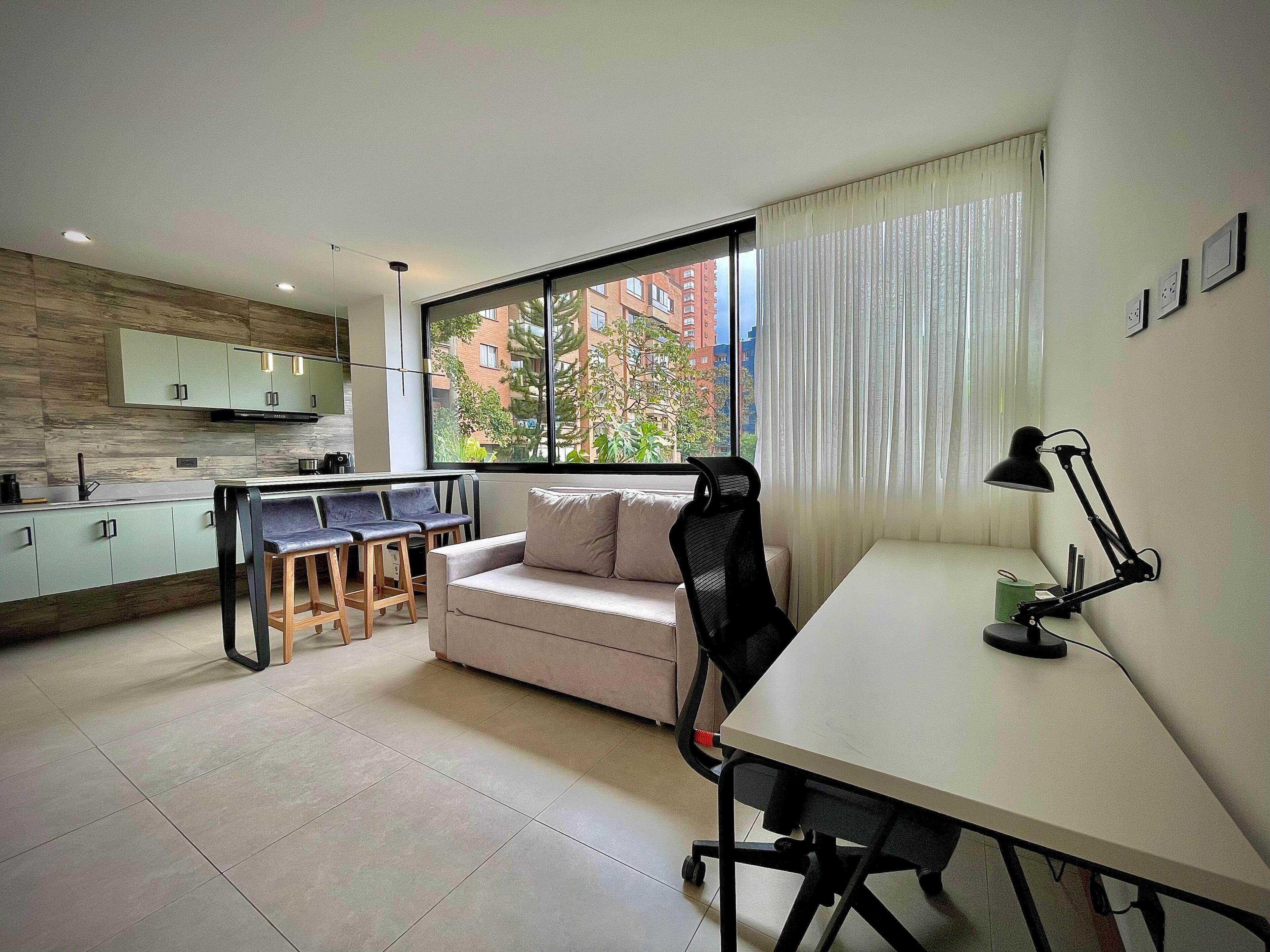A modern apartment with a kitchen, dining area, and a sofa.