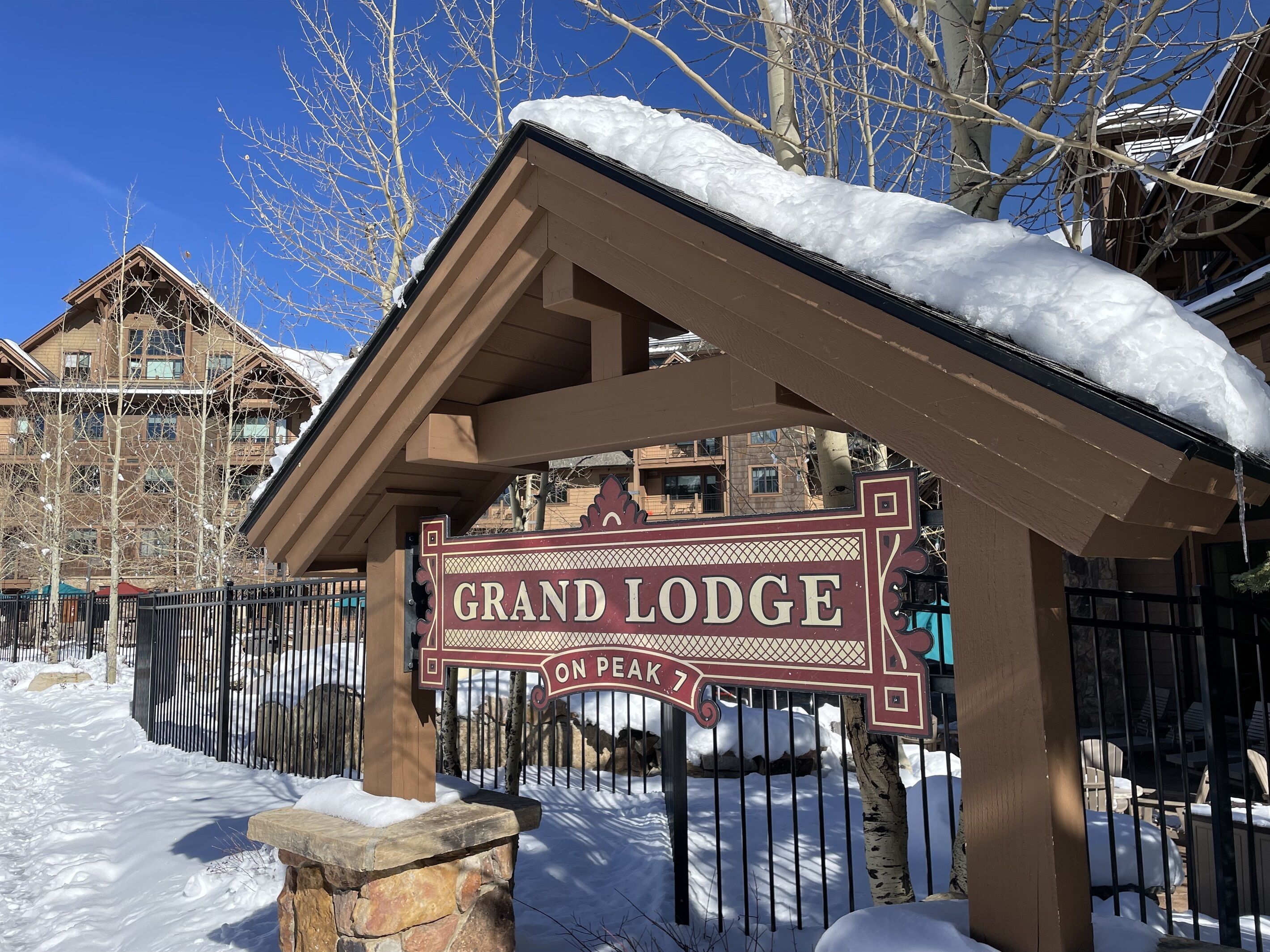 A snow-covered entrance sign for Grand Lodge on Peak 7.