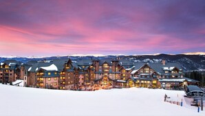 A large lodge with multiple buildings, ski lifts, and a snowy landscape.