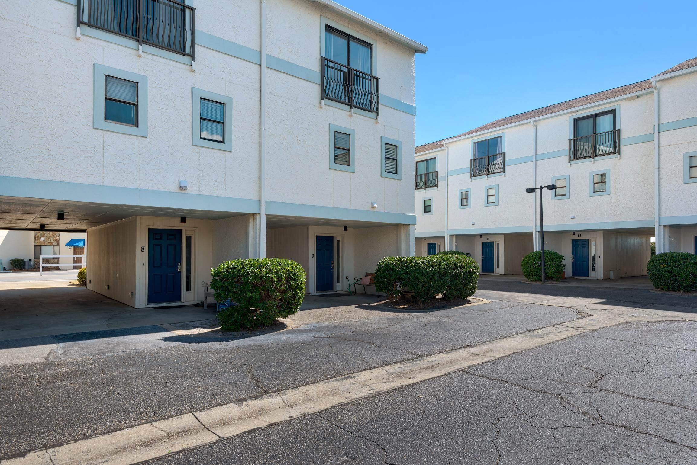 A multi-story residential building with a parking area in front.