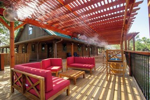 Une terrasse en bois avec des sièges rembourrés de couleur rouge et un jacuzzi.